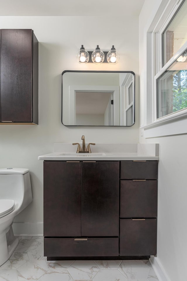 bathroom with vanity, marble finish floor, and baseboards