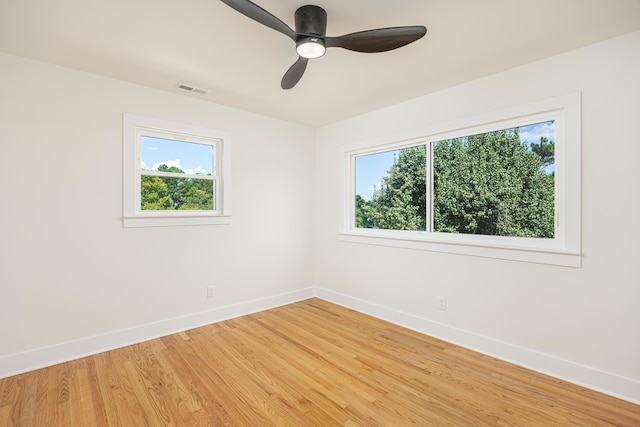 spare room with visible vents, baseboards, light wood-type flooring, and a healthy amount of sunlight