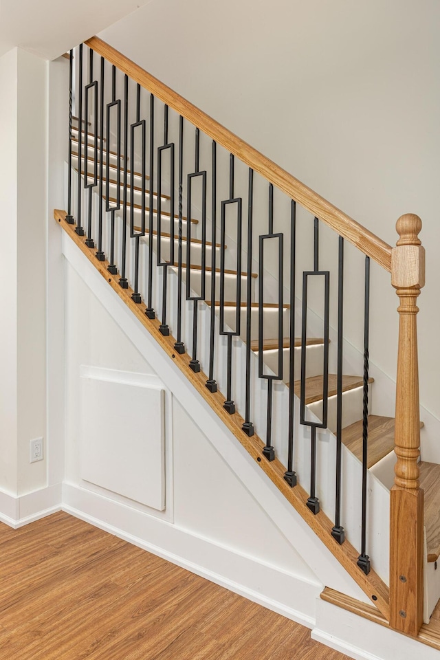 staircase featuring baseboards and wood finished floors