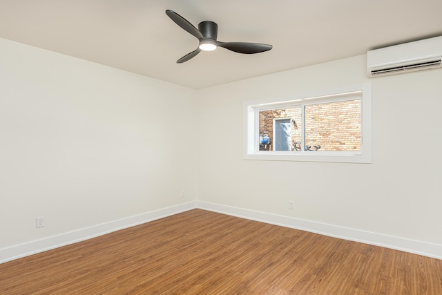 spare room with light wood-style flooring, ceiling fan, baseboards, and an AC wall unit