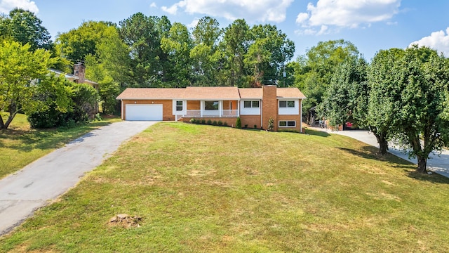 single story home featuring an attached garage, a chimney, aphalt driveway, brick siding, and a front lawn