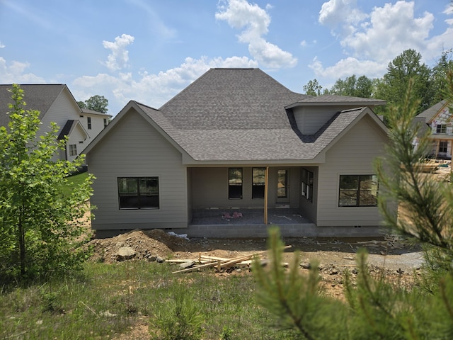 rear view of property featuring a patio and a shingled roof