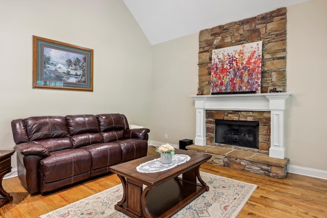 7415 Island Manor Dr, Harrison, TN 37341 - living area with vaulted ceiling, a stone fireplace, baseboards, and wood finished floors