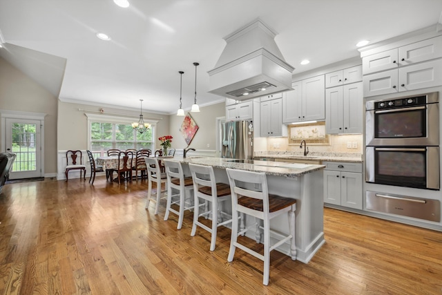7415 Island Manor Dr, Harrison, TN 37341 - kitchen featuring a warming drawer, stainless steel appliances, an island with sink, a chandelier, and a kitchen breakfast bar
