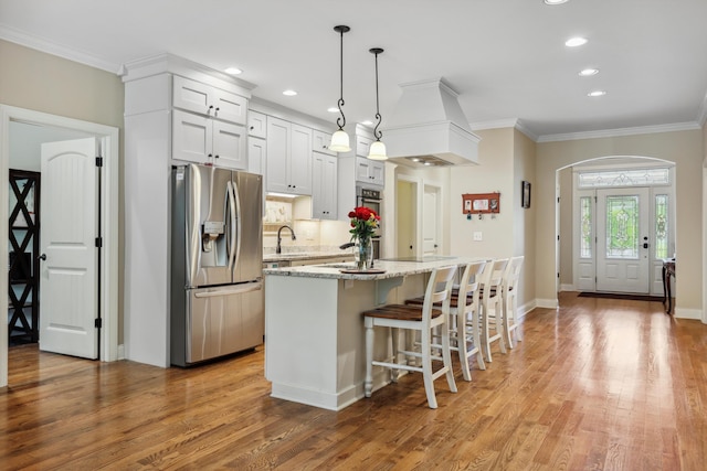 7415 Island Manor Dr, Harrison, TN 37341 - kitchen with stainless steel fridge, a sink, light wood-style floors, recessed lighting, and a center island with sink