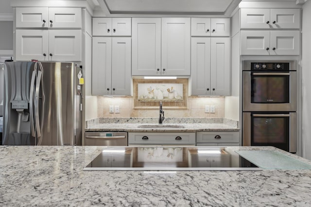7415 Island Manor Dr, Harrison, TN 37341 - kitchen featuring appliances with stainless steel finishes, a sink, white cabinetry, light stone countertops, and backsplash