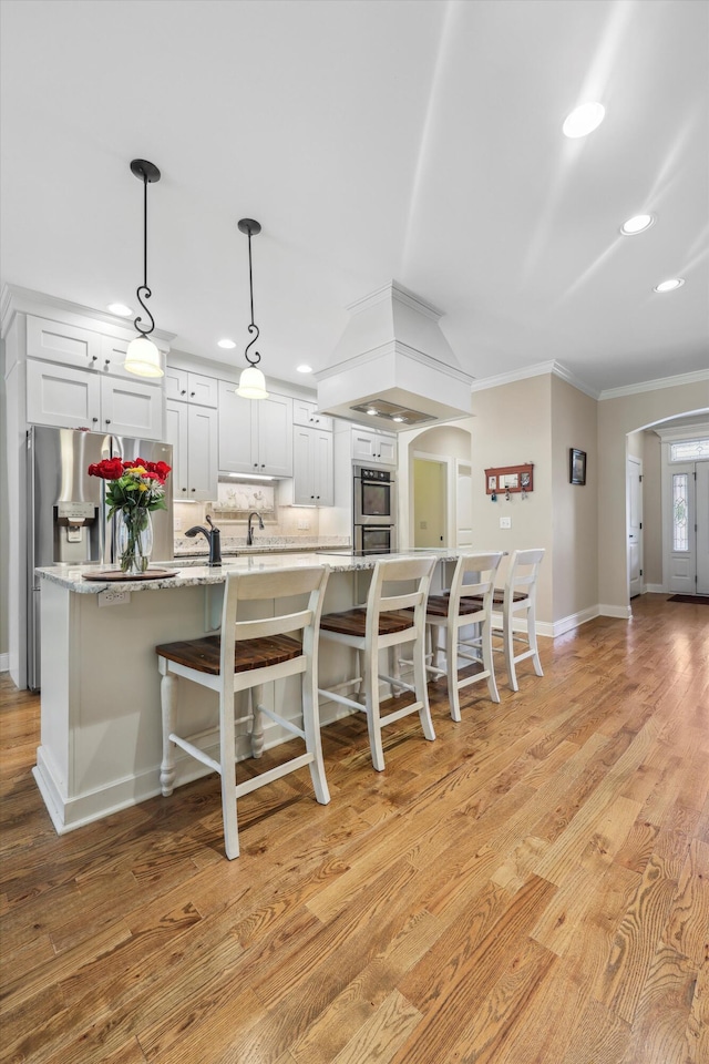 7415 Island Manor Dr, Harrison, TN 37341 - kitchen with arched walkways, crown molding, baseboards, recessed lighting, and white cabinets