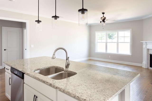 kitchen featuring dishwasher, a sink, ceiling fan, crown molding, and wood finished floors