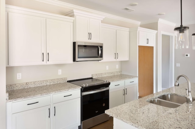 kitchen with a sink, appliances with stainless steel finishes, white cabinetry, and light stone countertops