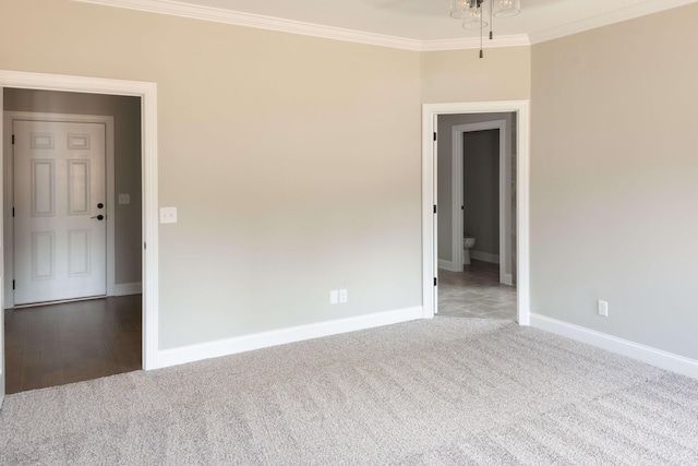 carpeted spare room with baseboards and ornamental molding