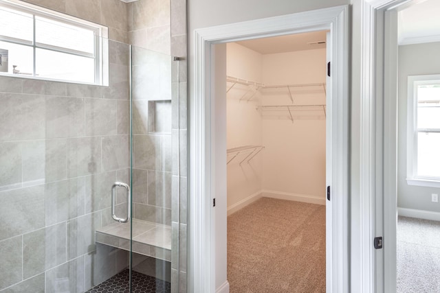 full bathroom with a stall shower, baseboards, and a walk in closet