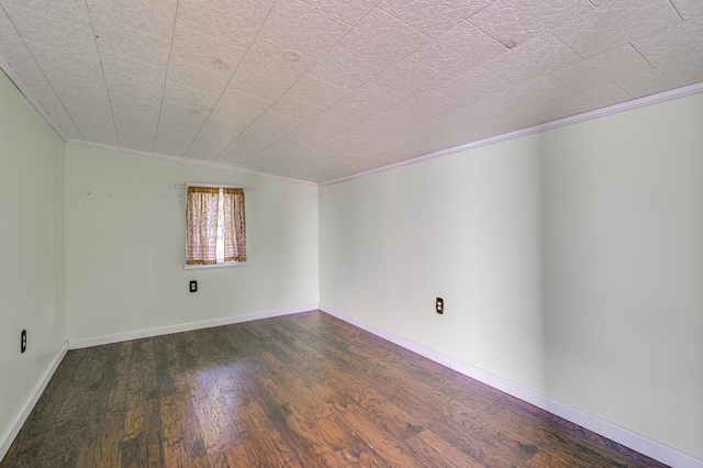 spare room with crown molding and dark wood-style floors