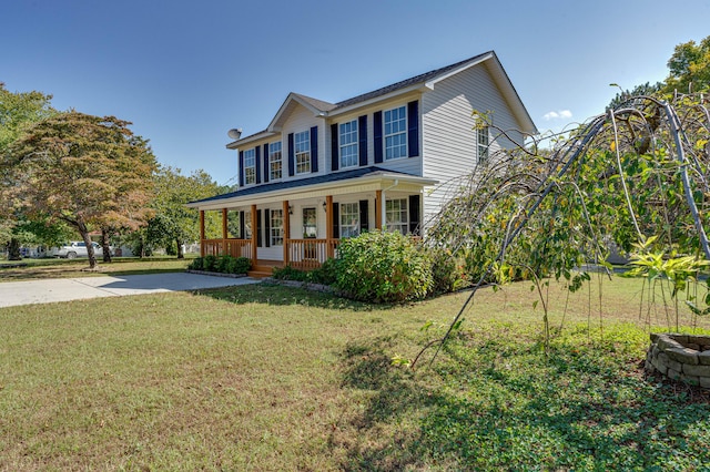 colonial-style house featuring a front lawn, covered porch, and driveway