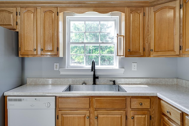 kitchen with light countertops, dishwasher, a sink, and freestanding refrigerator
