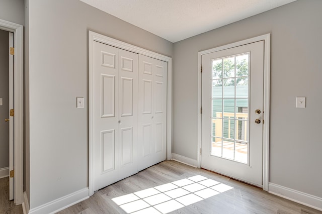 entryway with light wood-type flooring and baseboards