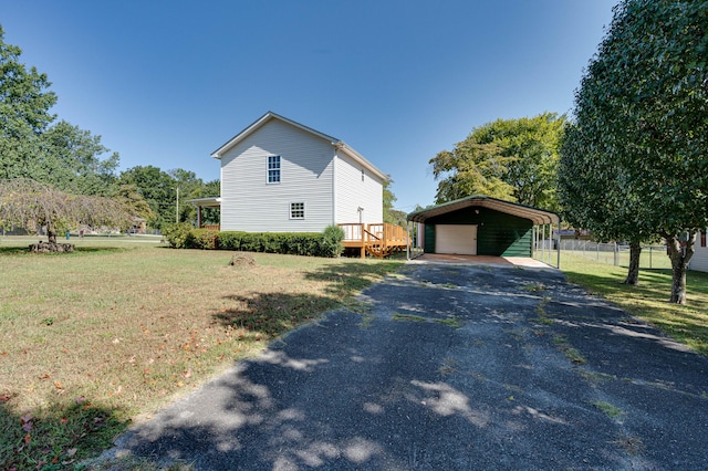 view of property exterior featuring an outdoor structure, a lawn, a detached carport, fence, and driveway