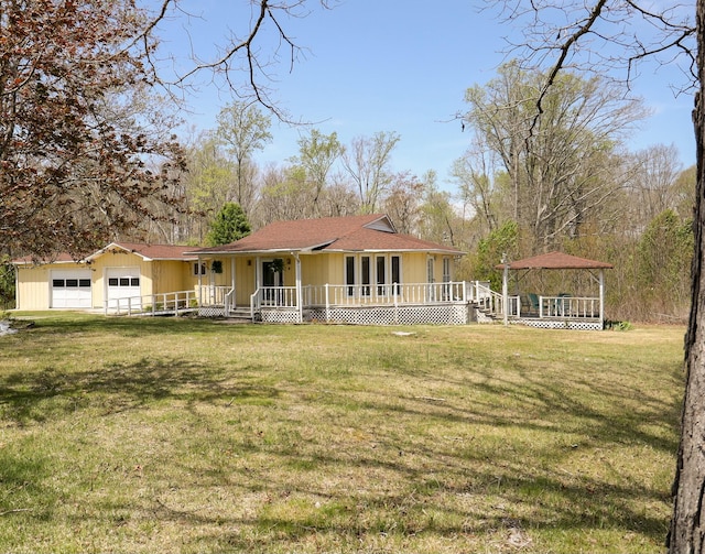 view of front facade featuring an attached garage, covered porch, and a front lawn