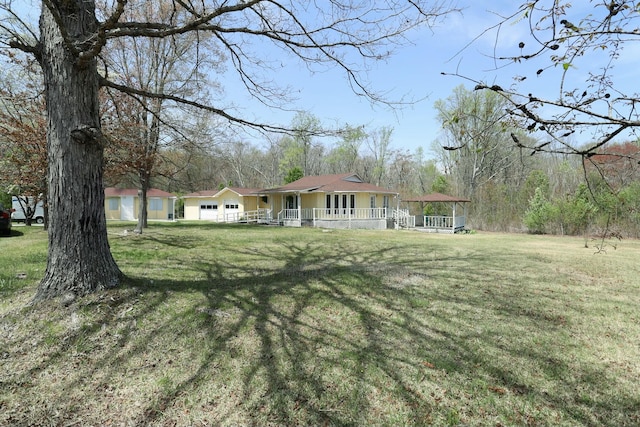 view of yard with covered porch and a garage