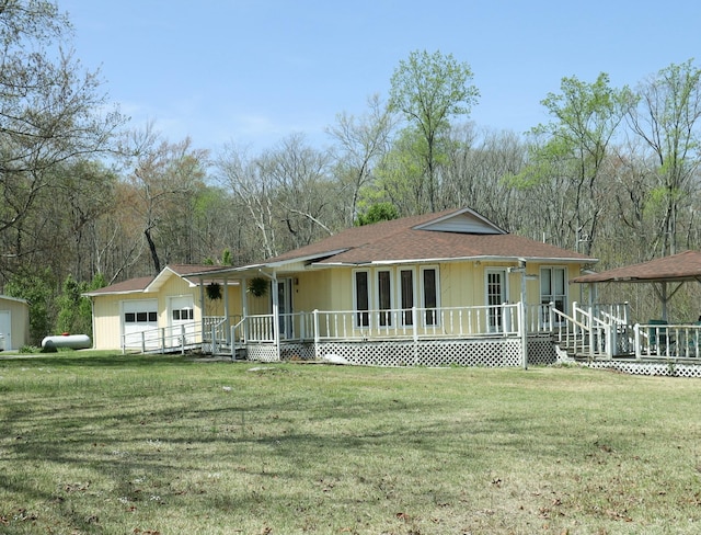 view of front facade with roof with shingles, a front yard, a porch, a garage, and a gazebo