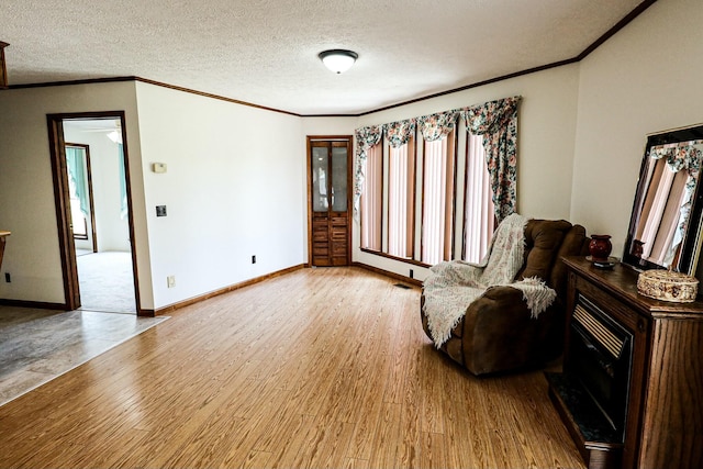 sitting room featuring crown molding, wood finished floors, plenty of natural light, and a textured ceiling