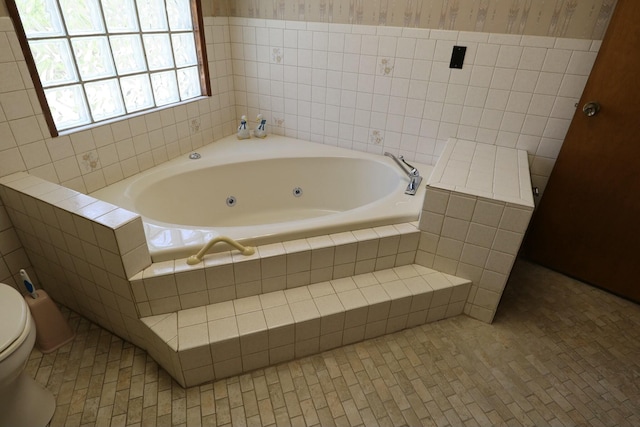 full bath featuring tile patterned flooring, wallpapered walls, toilet, and a tub with jets