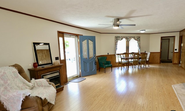 interior space featuring light wood-style flooring, a healthy amount of sunlight, and a wainscoted wall