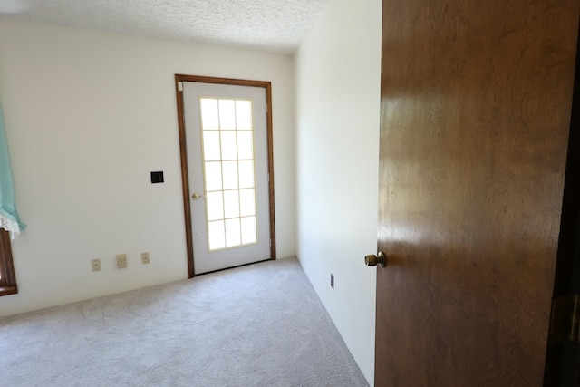 carpeted spare room featuring a textured ceiling