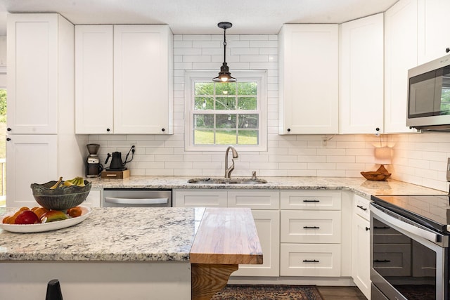 kitchen with a sink, white cabinetry, and stainless steel appliances