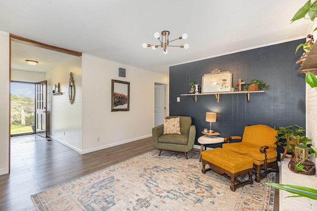 living area featuring baseboards, wood finished floors, and a notable chandelier