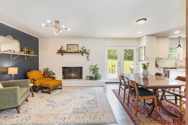 interior space featuring french doors, wood finished floors, a chandelier, and a fireplace