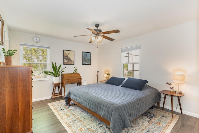 bedroom featuring baseboards, ceiling fan, and wood finished floors