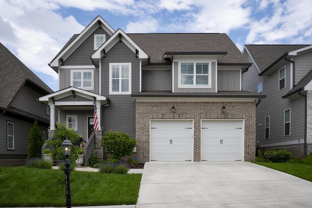 craftsman inspired home featuring a garage, concrete driveway, brick siding, a front lawn, and board and batten siding