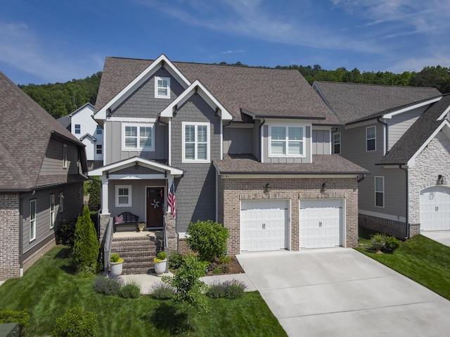 craftsman-style home with board and batten siding, a porch, concrete driveway, and a garage