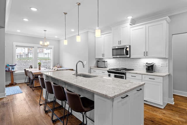 9876 Trestle Cir, Ooltewah, TN 37363 - kitchen featuring white cabinets, stainless steel appliances, backsplash, a sink, and a kitchen island with sink