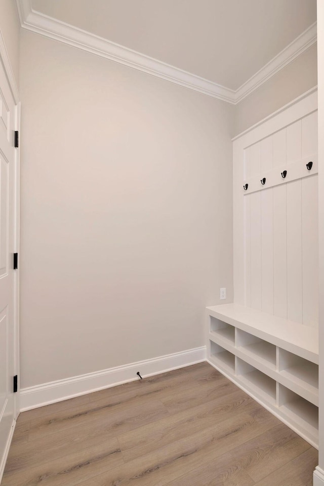mudroom with ornamental molding, baseboards, and wood finished floors