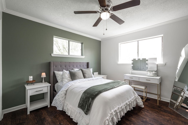 bedroom with a textured ceiling, multiple windows, crown molding, and wood finished floors