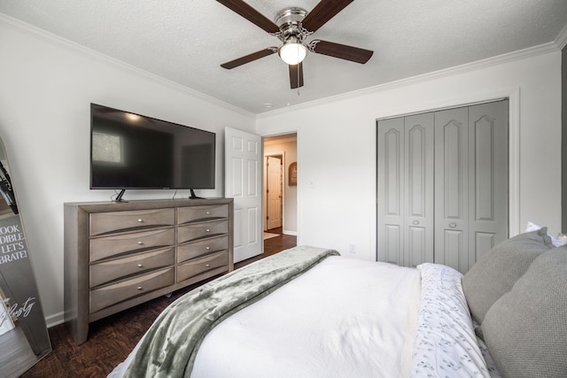 bedroom with crown molding, ceiling fan, dark wood-type flooring, a closet, and baseboards
