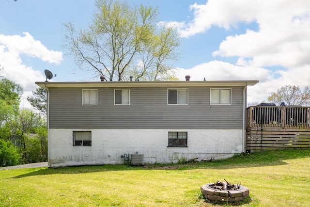 view of property exterior with a yard, an outdoor fire pit, and central AC unit
