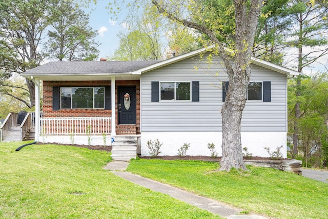 view of front of home with a front lawn, a shingled roof, and a porch