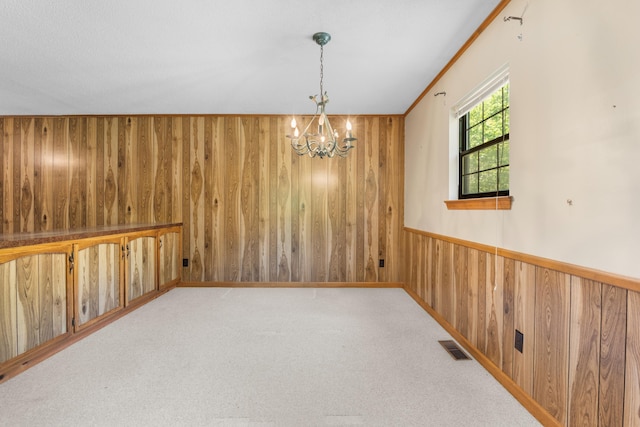 401 Laymons Rd, Hixson, TN 37343 - empty room featuring visible vents, wood walls, an inviting chandelier, and carpet floors
