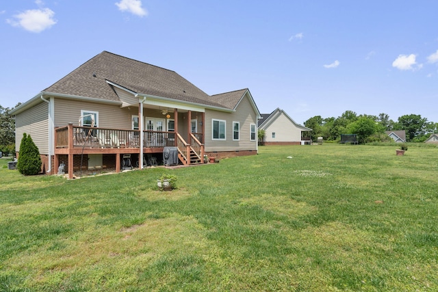 back of house featuring a yard, a deck, and roof with shingles