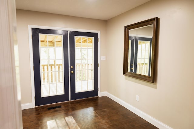 doorway featuring dark wood-style floors, visible vents, baseboards, and french doors