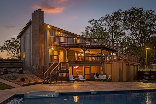 6500 Waconda Point Rd, Harrison, TN 37341 - back of property at dusk with an outdoor pool, a wooden deck, a patio, and stairs
