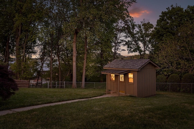6500 Waconda Point Rd, Harrison, TN 37341 - outdoor structure at dusk with a fenced backyard, an outbuilding, a yard, and a storage shed