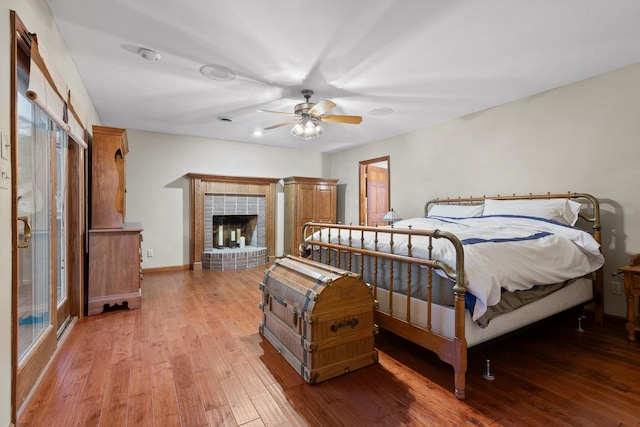 6500 Waconda Point Rd, Harrison, TN 37341 - bedroom featuring a fireplace, light wood-type flooring, a ceiling fan, and baseboards