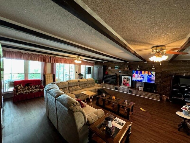 living room featuring a ceiling fan, beamed ceiling, wood finished floors, a textured ceiling, and brick wall
