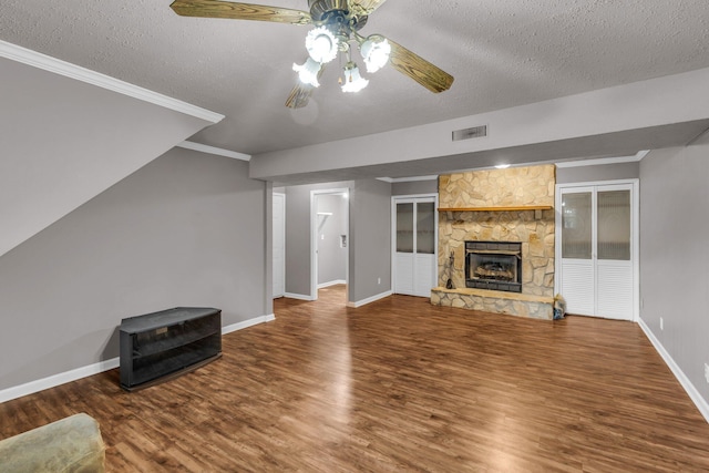 unfurnished living room featuring a textured ceiling, visible vents, and wood finished floors