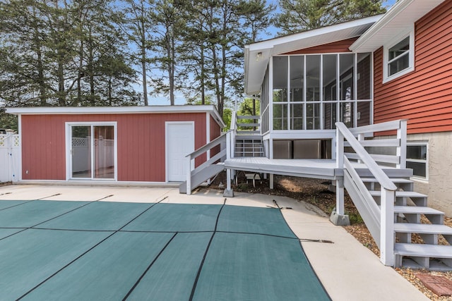 back of house featuring an outdoor structure, a patio area, stairs, and a sunroom