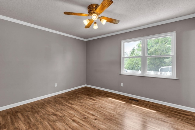 unfurnished room with wood finished floors, baseboards, visible vents, a textured ceiling, and crown molding