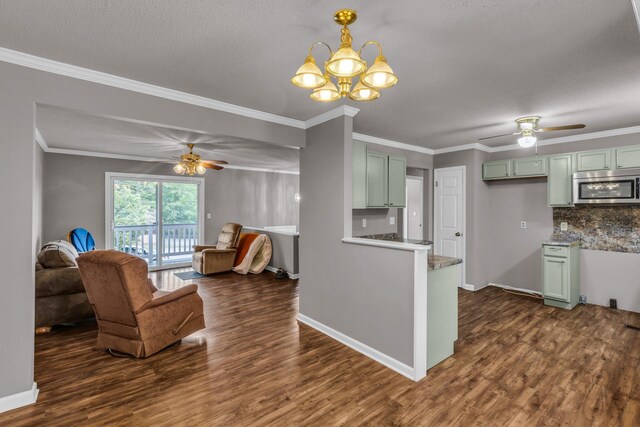 kitchen featuring dark wood finished floors, ceiling fan with notable chandelier, green cabinets, and stainless steel microwave